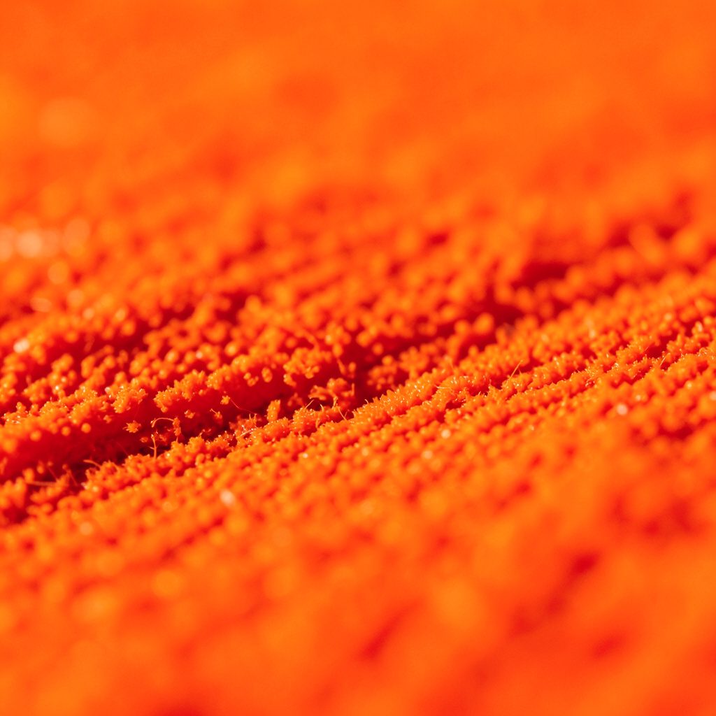 Extreme close-up of a cracked carbohydrate crystal surface in gold and burgundy hues