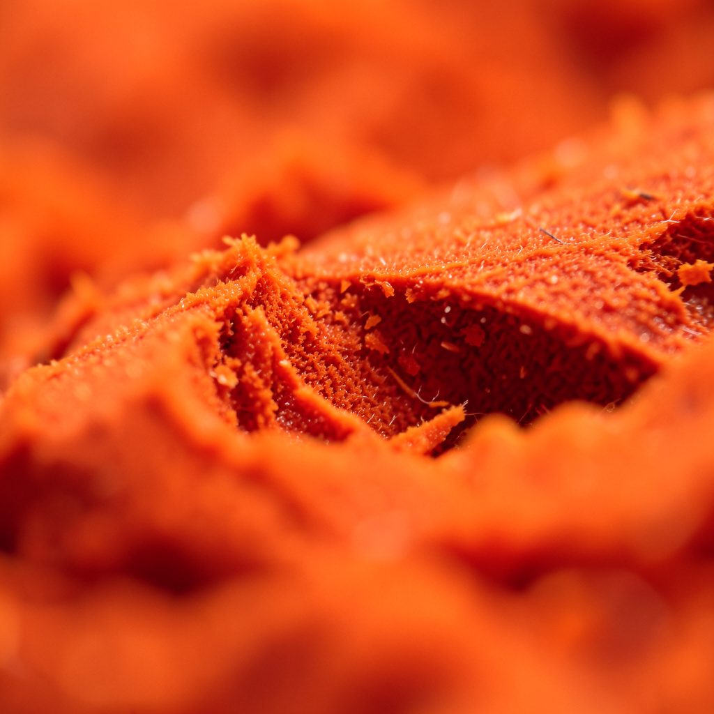 Close-up abstract texture with warm maroon and gold tones evoking an academic conference setting