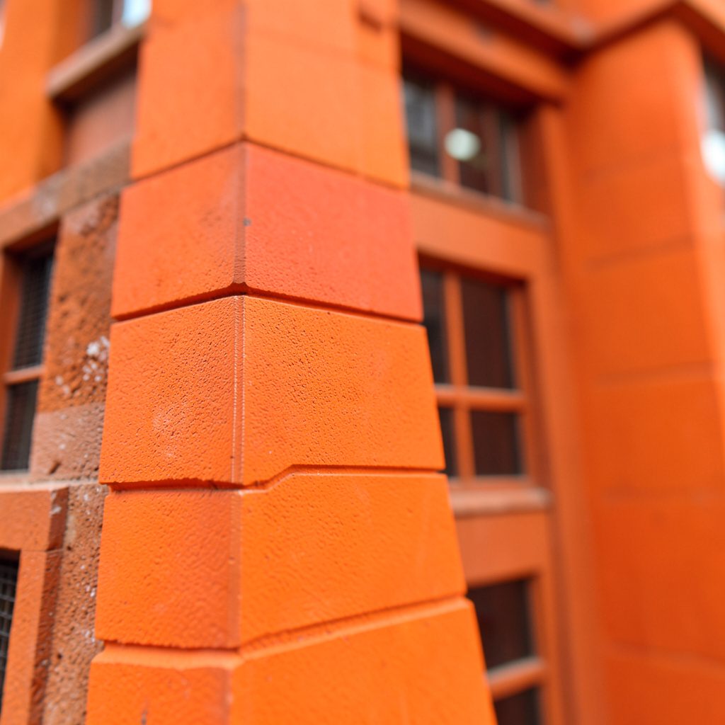 Facade of a grand historic concert hall building in warm stone and dark shadow tones